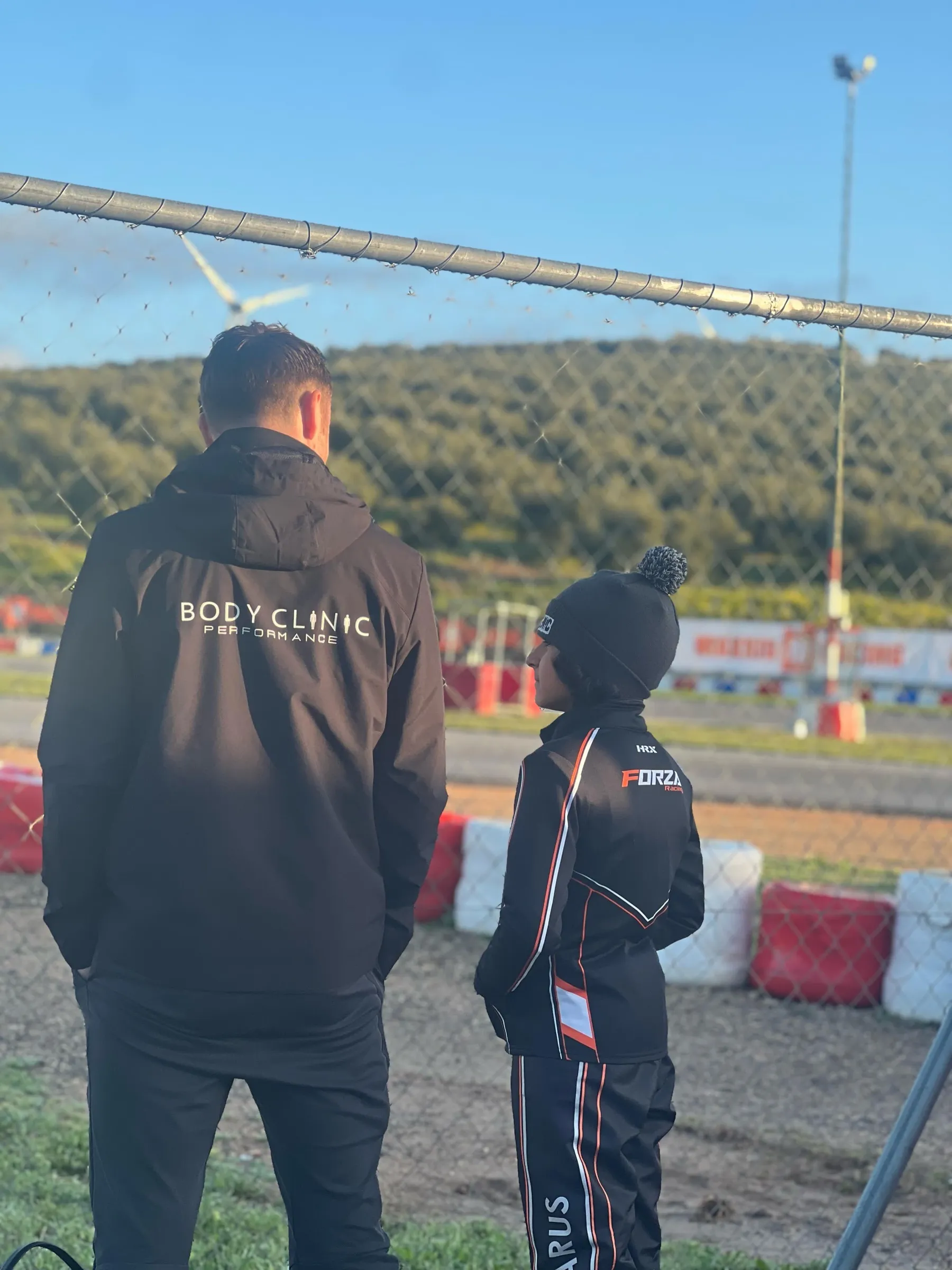 Coach and driver watching the circuit from the paddock