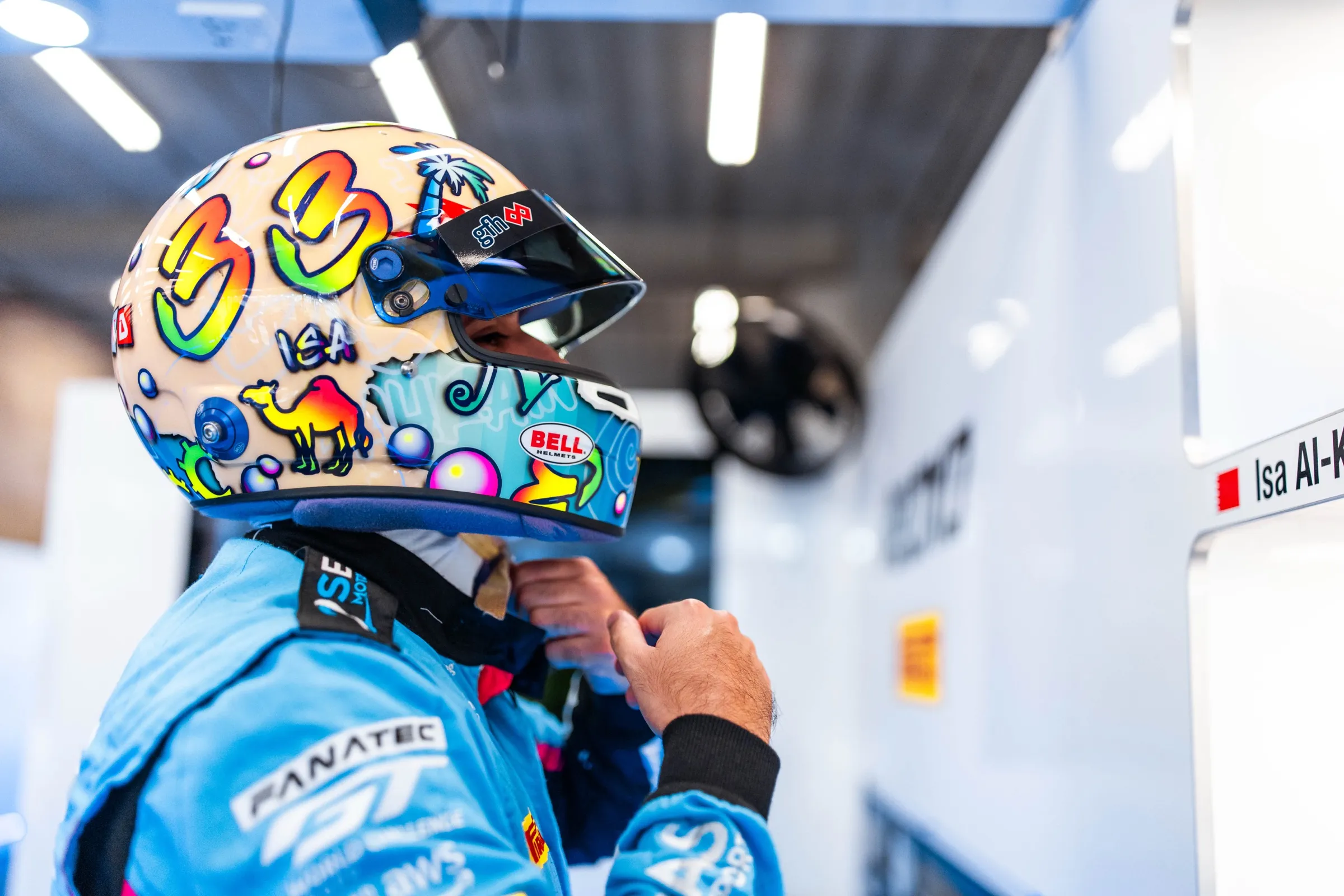 GT3 driver fastening a helmet in the garage