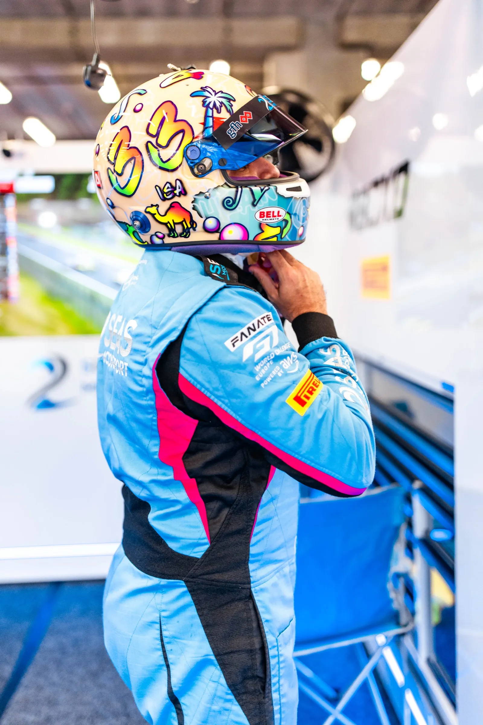 GT3 driver pulling on a helmet in the garage