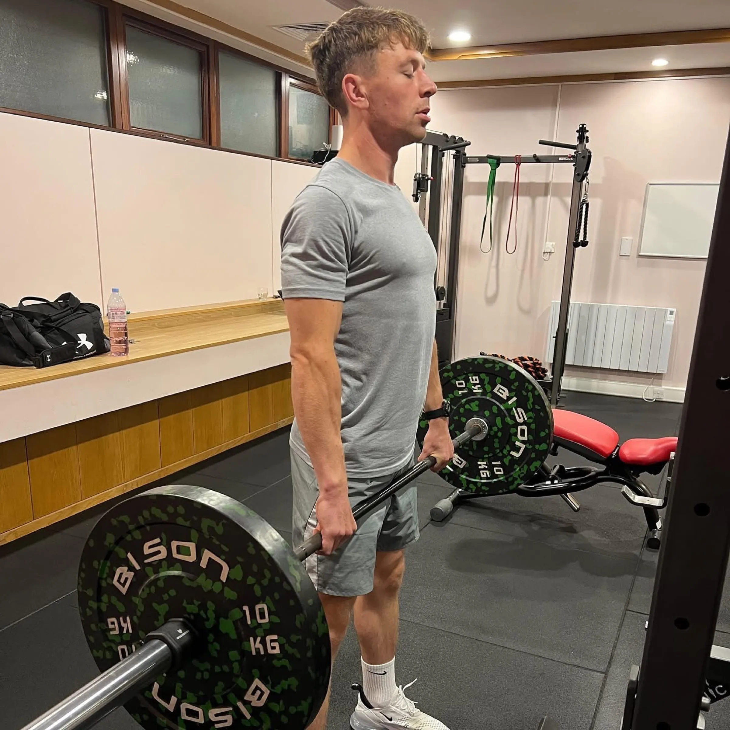 Adult client lifting a barbell in the gym