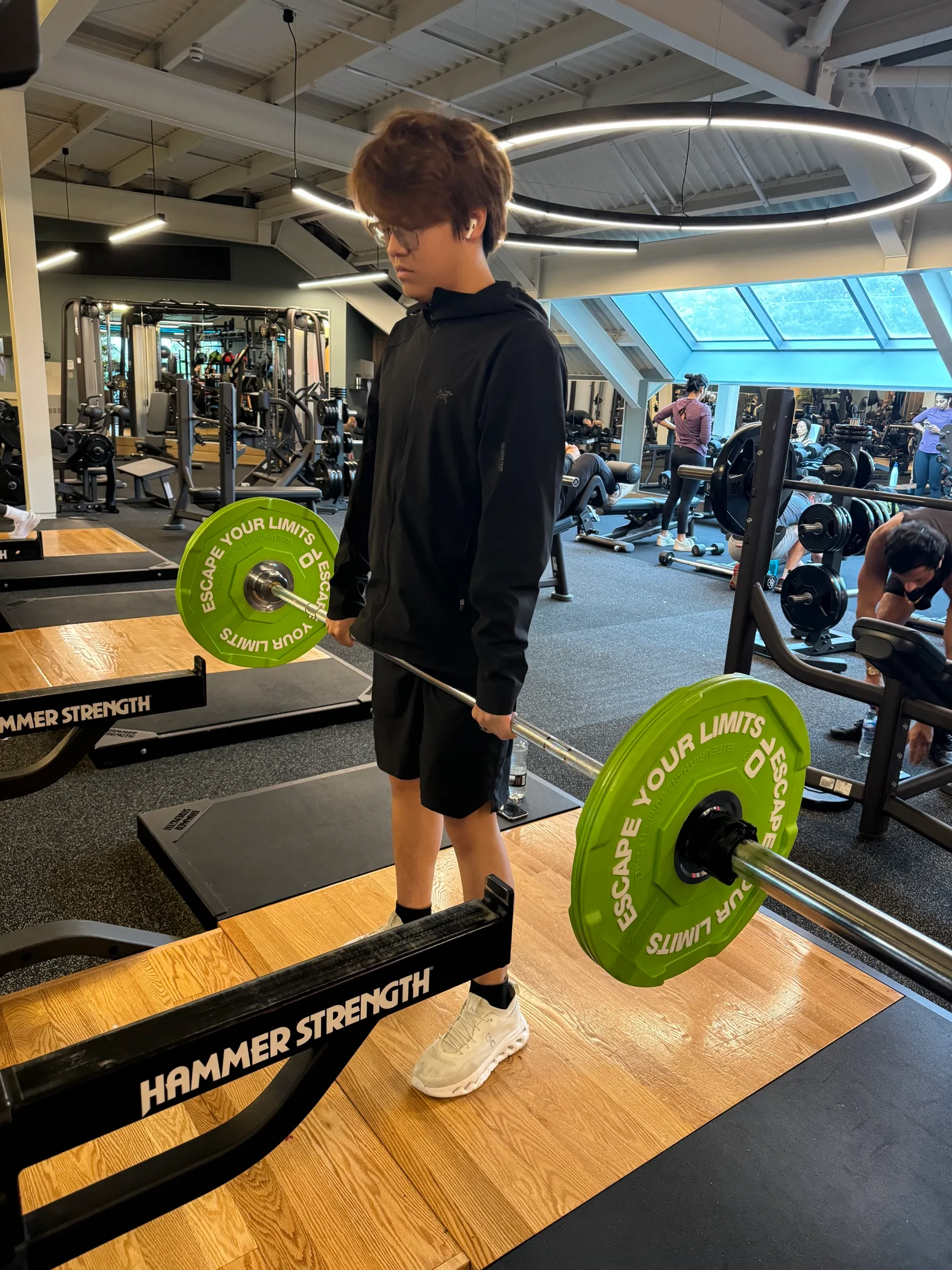 Young driver deadlifting under coach supervision