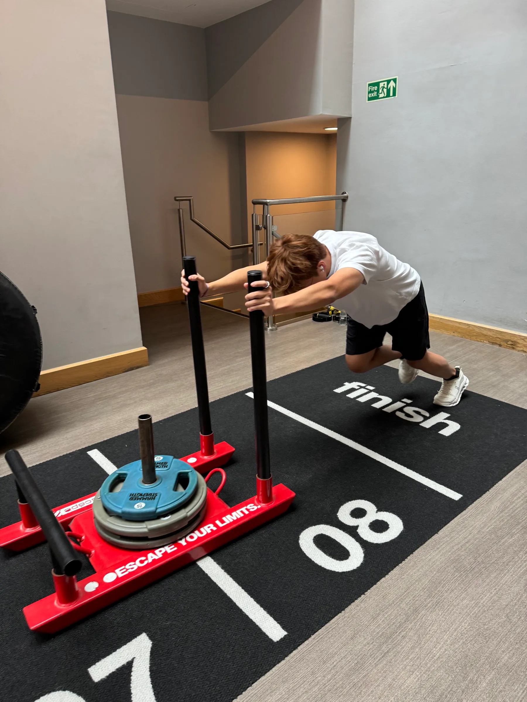 Athlete pushing a weighted sled in the gym