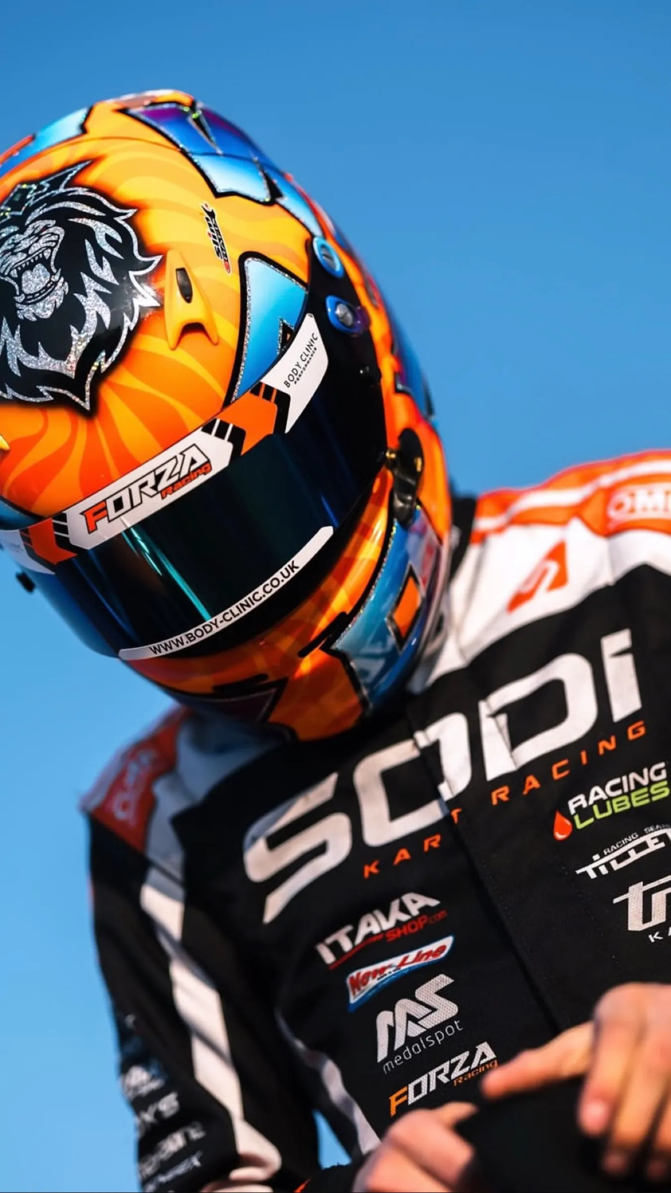Karting driver in a Sodi race suit, helmet on