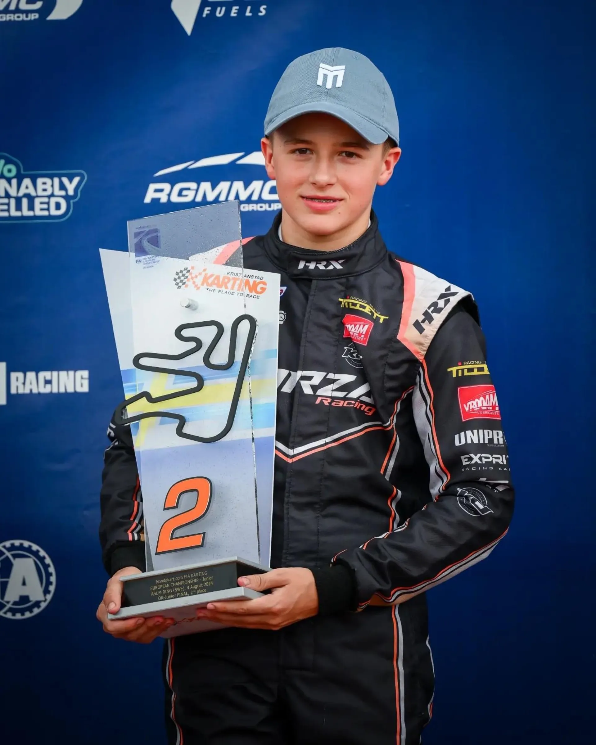 Karting driver holding a trophy on the podium