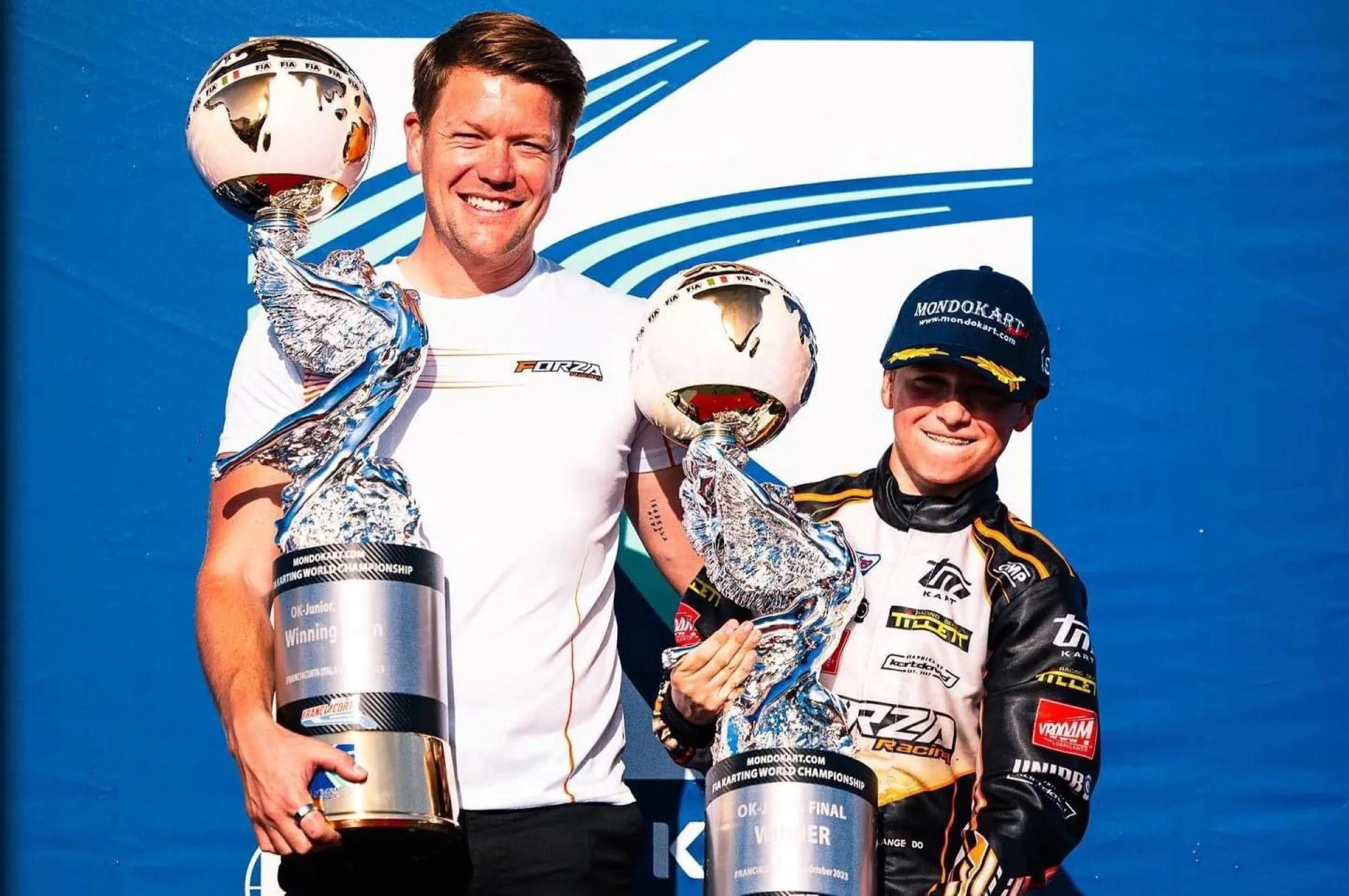 Driver on the podium with trophies